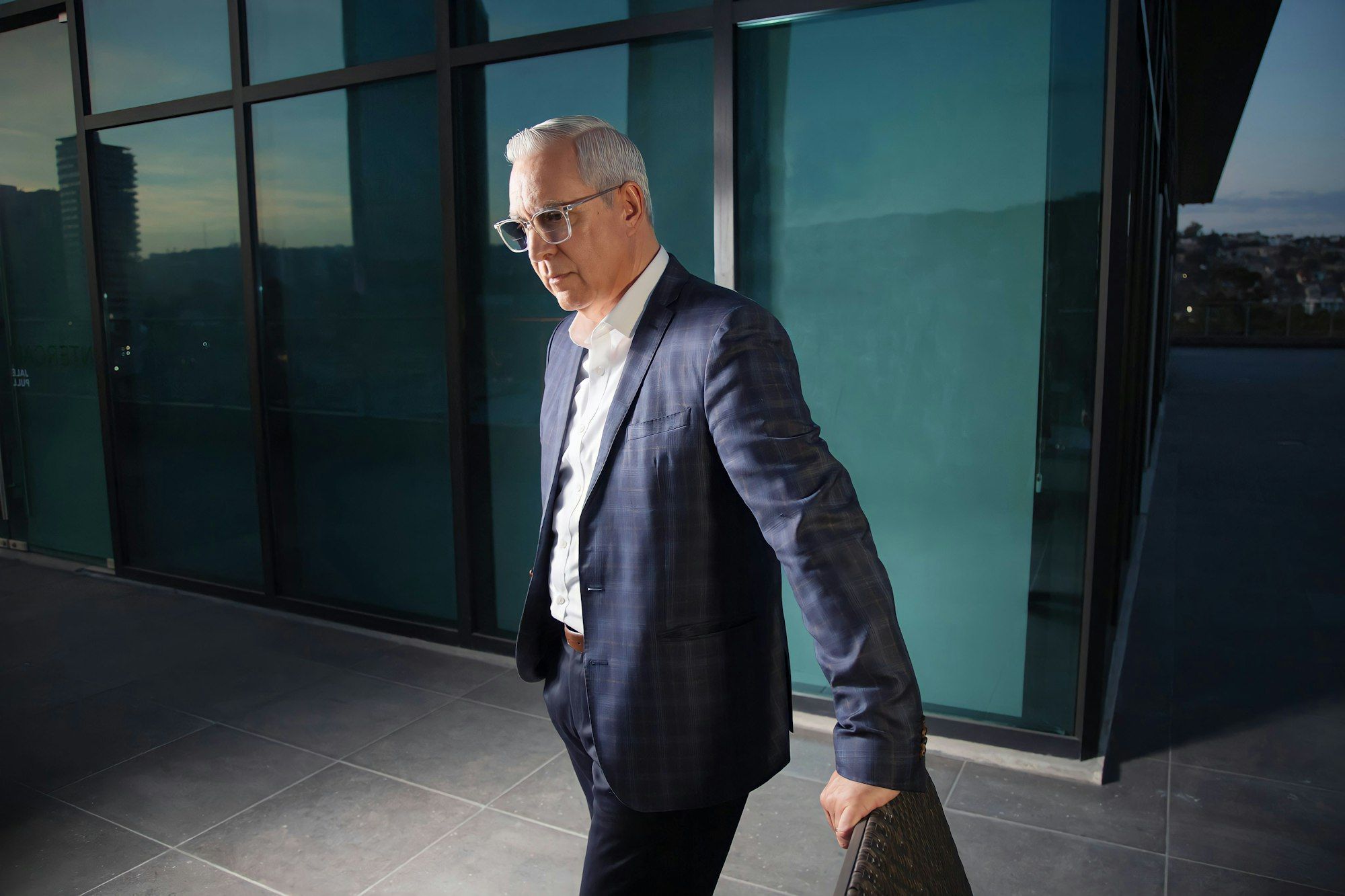 Senior executive walking past a glass facade